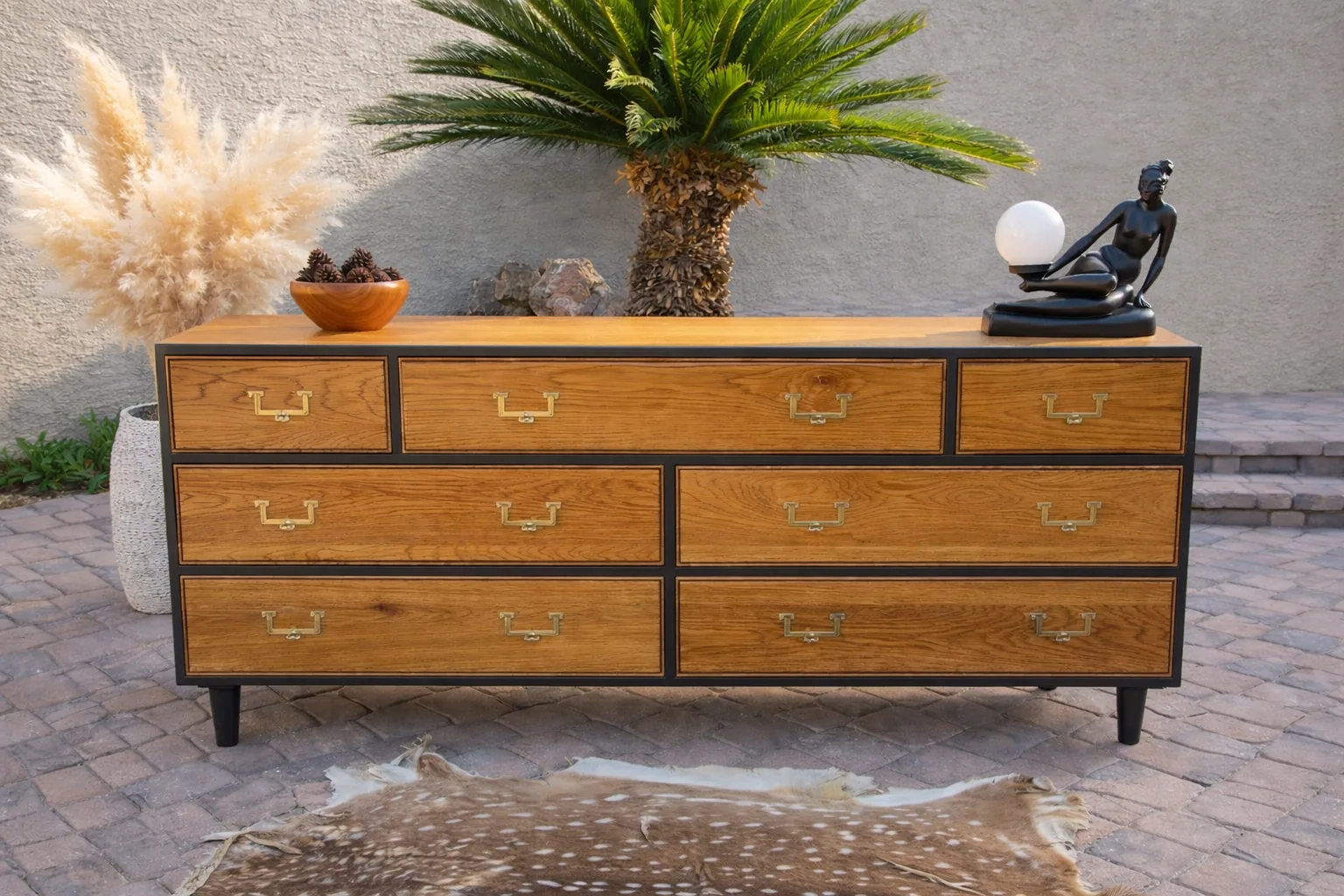 Restored vintage dresser with natural wood grain, brass pulls, and black trim