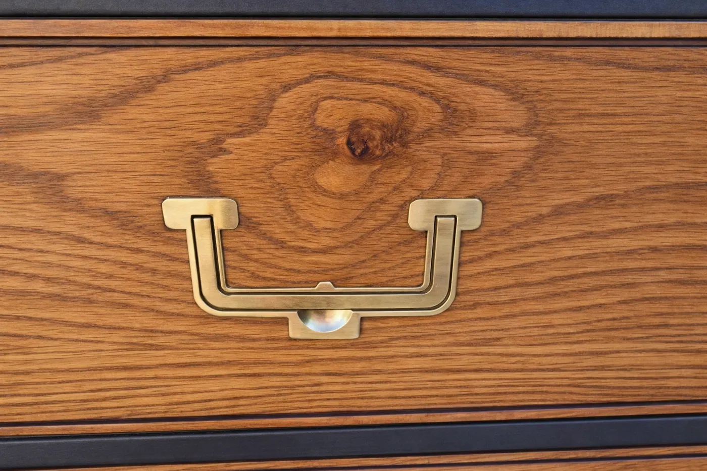 Close view of restored wood grain and brass drawer pull